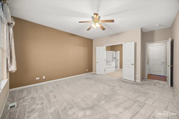 an empty room with fan and entrance