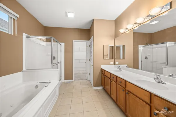 a bathroom with a tub sink shower and mirror