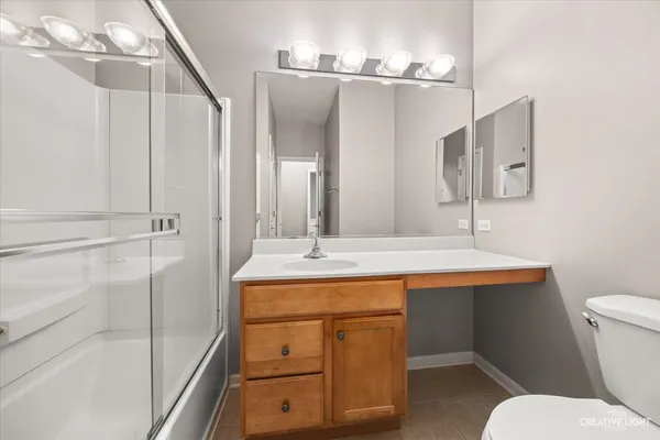 a bathroom with a sink a toilet a mirror and shower