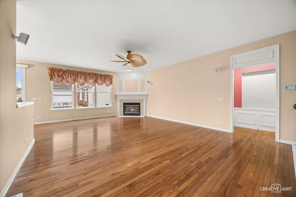 a view of an empty room with window and wooden floor