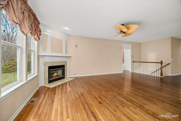 a view of empty room with wooden floor and fireplace