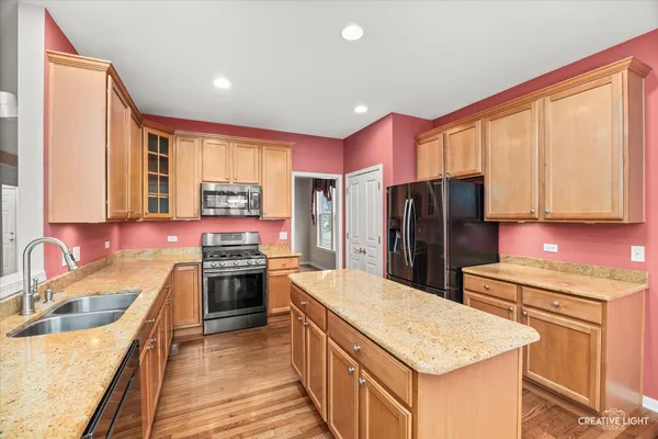 a kitchen with stainless steel appliances granite countertop a sink stove refrigerator and a window