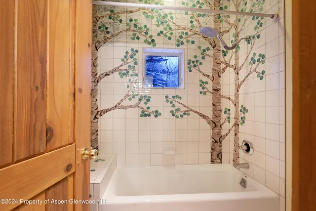 a living room with furniture a table and kitchen view