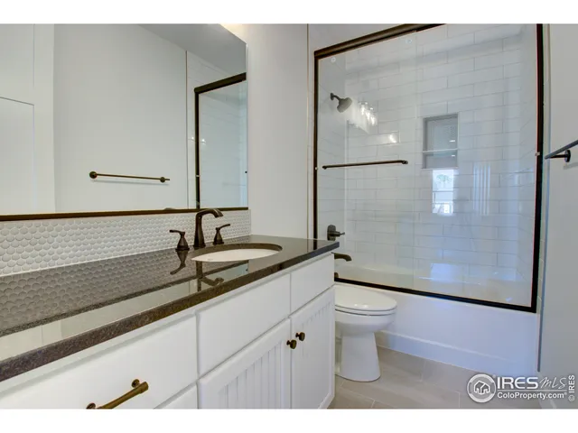 a bathroom with a sink double vanity granite tub shower and a mirror