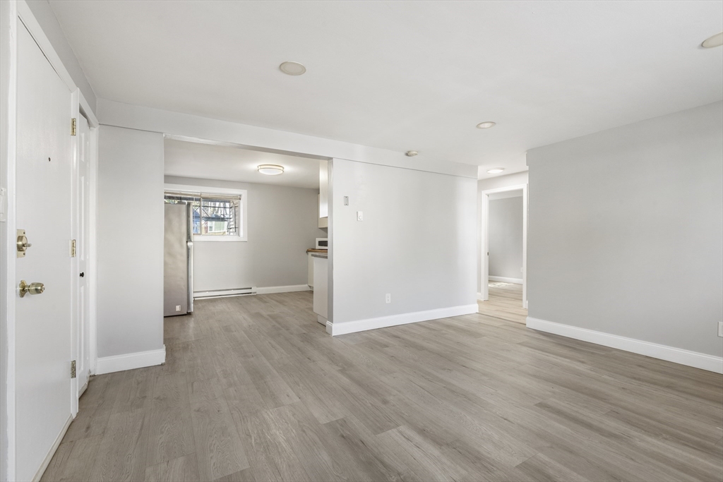 96 Itasca Street, Unit 961 Boston, MA 02126 - Photo 2 of 18 a view of an empty room with wooden floor and a window