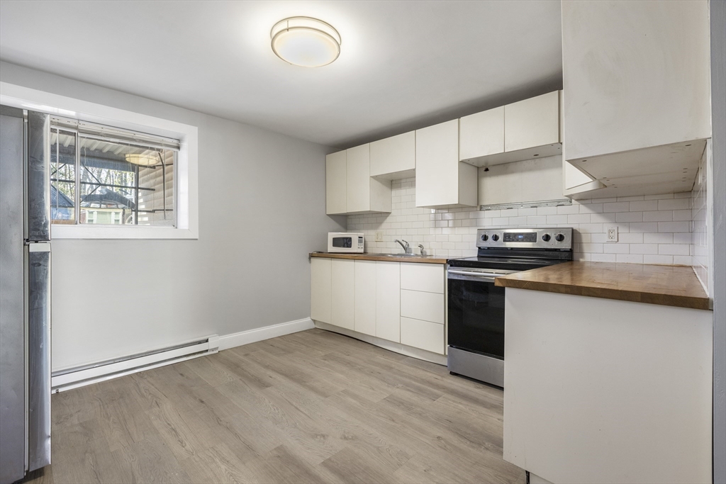96 Itasca Street, Unit 961 Boston, MA 02126 - Photo 3 of 18 a kitchen with granite countertop a sink cabinets and stainless steel appliances