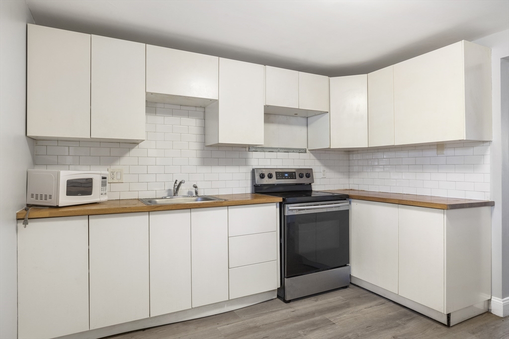 96 Itasca Street, Unit 961 Boston, MA 02126 - Photo 4 of 18 a kitchen with granite countertop white cabinets and white appliances