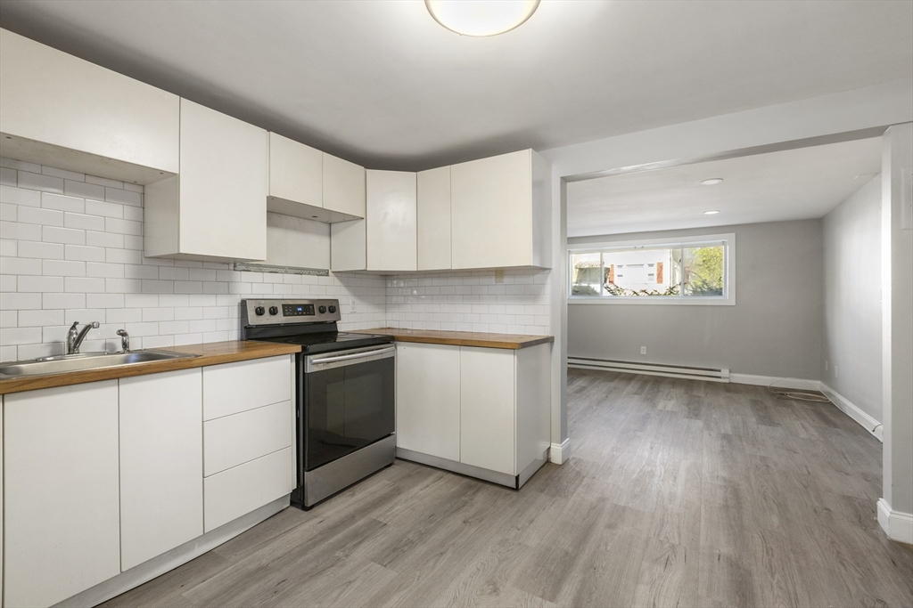 96 Itasca Street, Unit 961 Boston, MA 02126 - Photo 5 of 18 a kitchen with granite countertop white cabinets and white appliances
