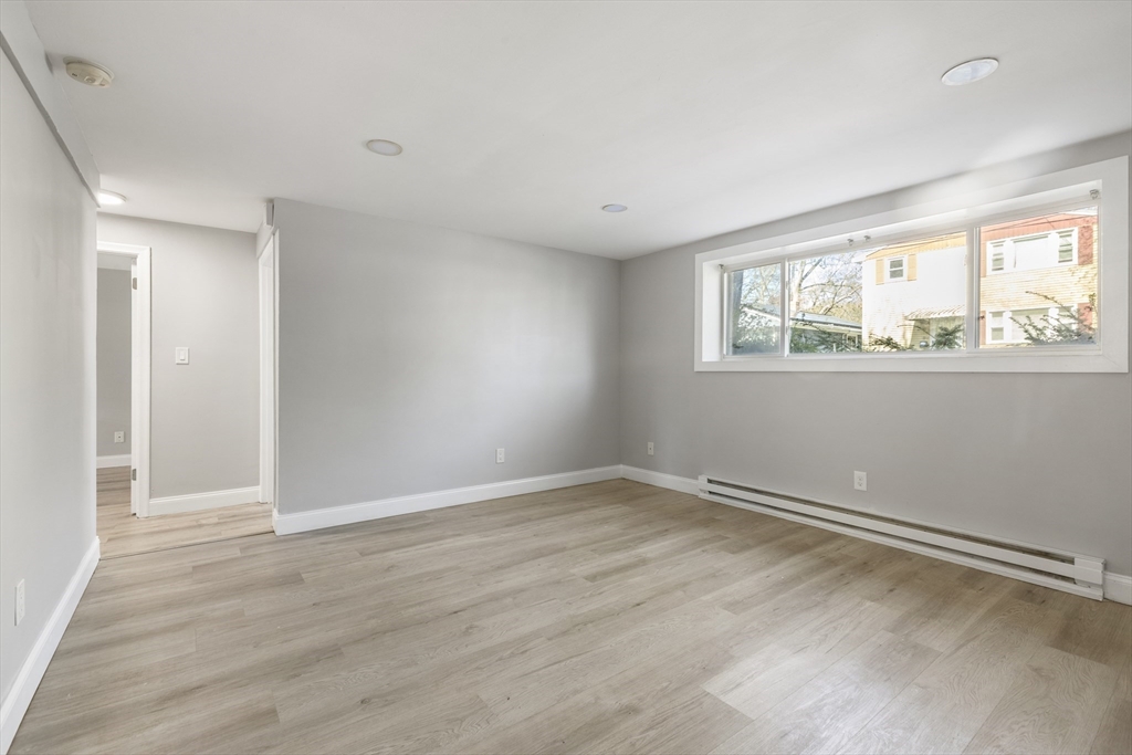 96 Itasca Street, Unit 961 Boston, MA 02126 - Photo 7 of 18 a view of an empty room with wooden floor and a window
