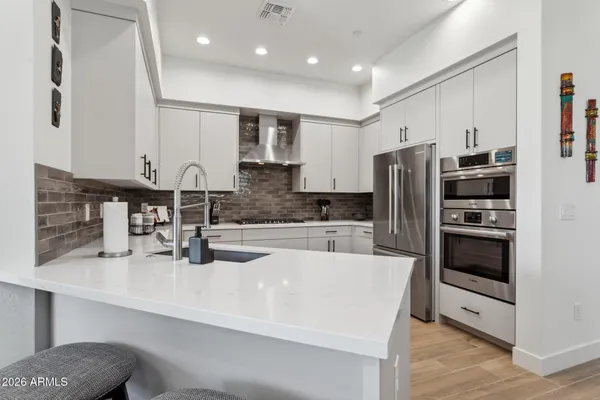 a kitchen with stainless steel appliances granite countertop a sink and a refrigerator