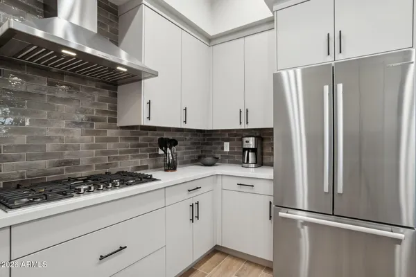 a kitchen with stainless steel appliances white cabinets and a stove top oven