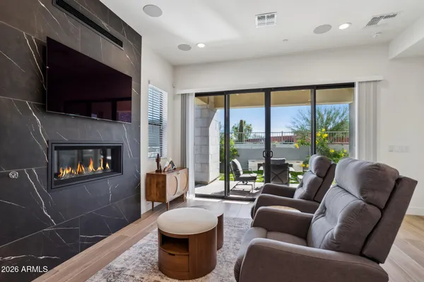 a living room with furniture a flat screen tv and a floor to ceiling window