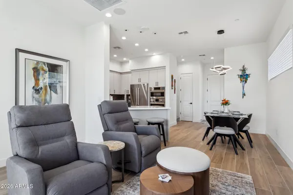 a living room with furniture a dining table and a potted plant