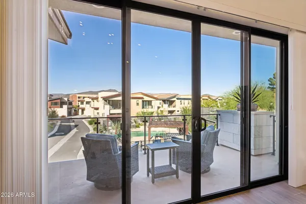 a view of a living room with a floor to ceiling window and wooden floor