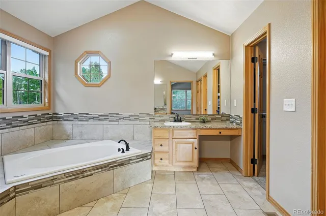 a spacious bathroom with a granite countertop sink and a mirror