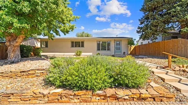 a front view of house with yard and trees in the background