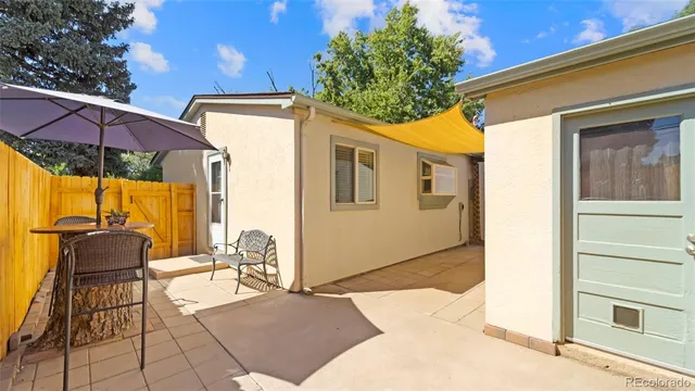 a backyard of a house with table and chairs