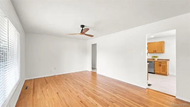 a view of a room with wooden floor and a ceiling fan