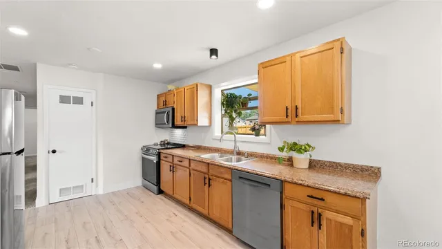 a kitchen with stainless steel appliances granite countertop a sink stove and refrigerator