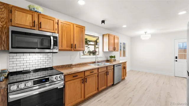 a kitchen with stainless steel appliances a stove microwave and sink