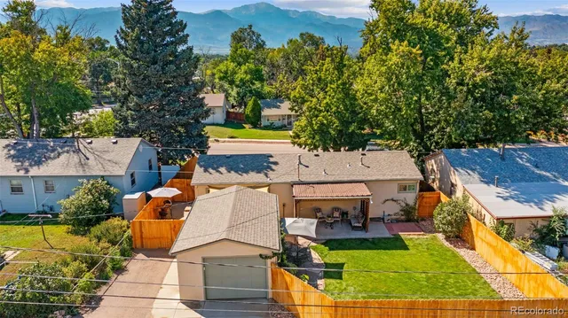 an aerial view of a house with swimming pool and large trees