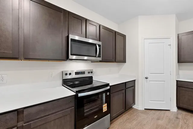 a kitchen with stainless steel appliances a stove microwave and sink
