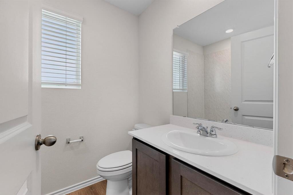7008 Vining Drive Princeton, TX 75407 - Photo 19 of 34 a bathroom with a sink toilet and a mirror