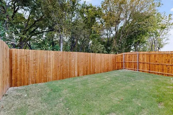 a view of backyard with wooden fence