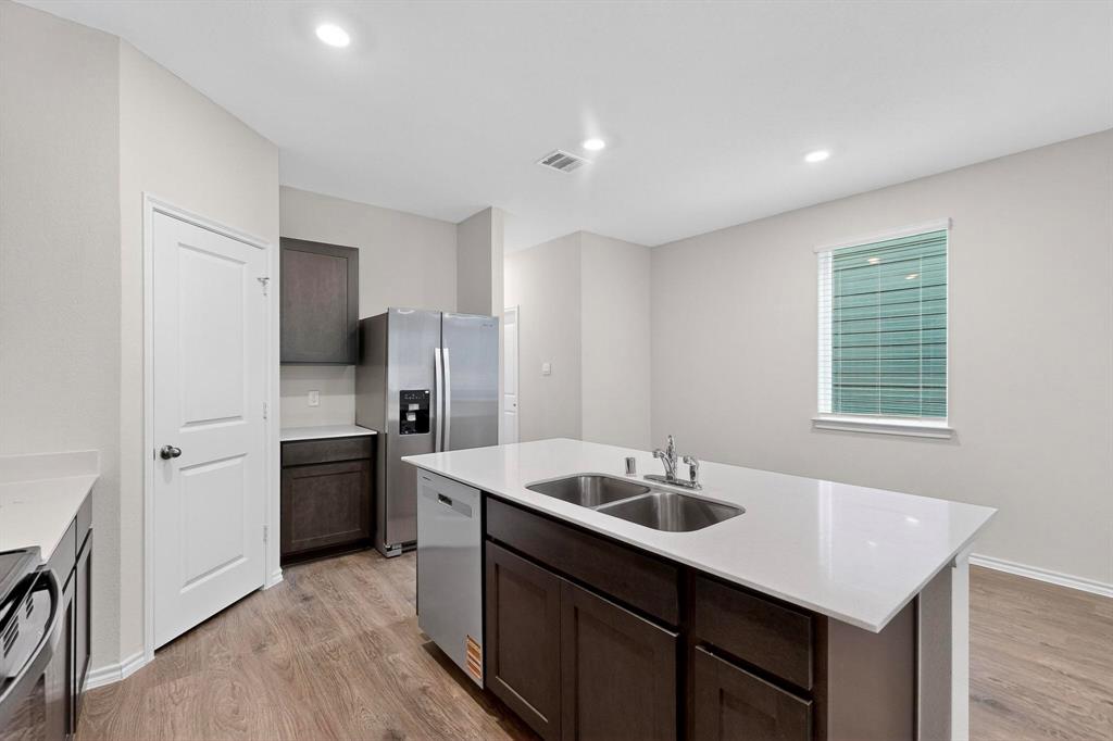 7008 Vining Drive Princeton, TX 75407 - Photo 10 of 34 a kitchen with stainless steel appliances granite countertop a sink stove and refrigerator