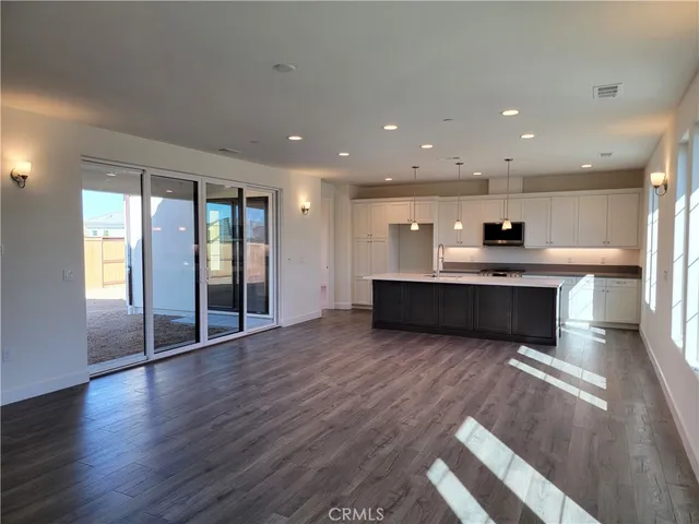 a view of kitchen with kitchen island wooden floor and center island