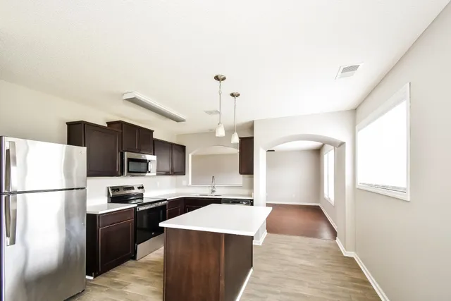 a kitchen with stainless steel appliances a refrigerator stove microwave and sink