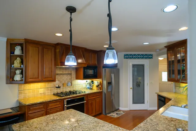 a kitchen with granite countertop stove and cabinets