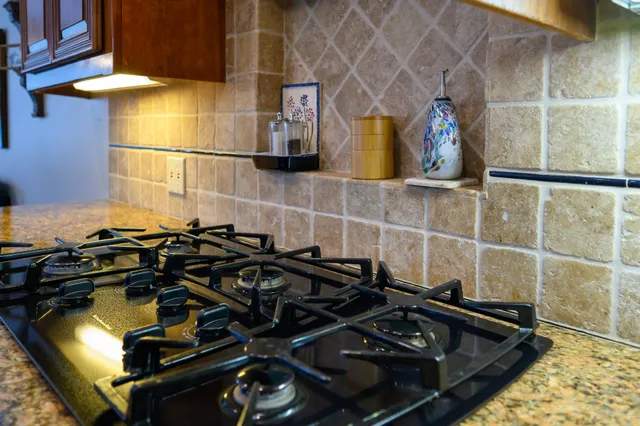 a close view of a sink a stove and a mirror