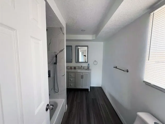 a bathroom with a sink a toilet a window and mirror