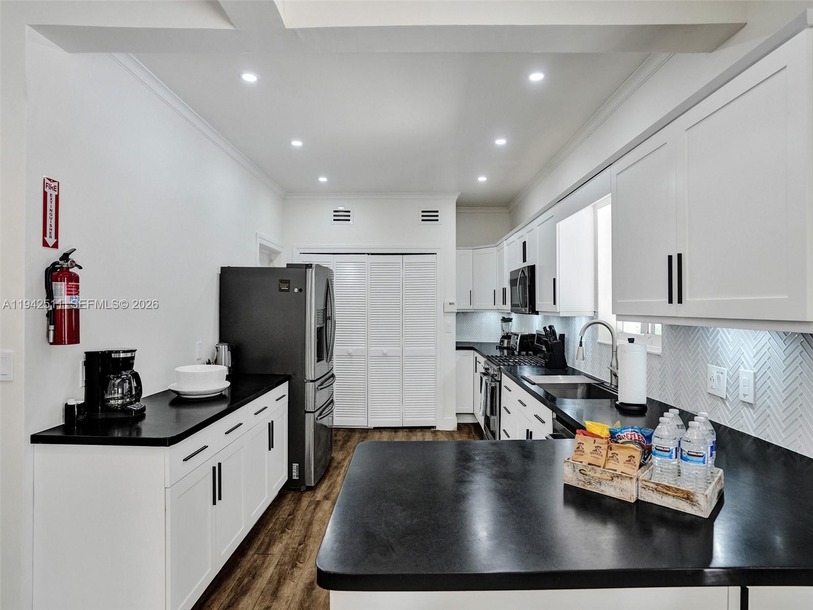 1128 Tyler Street Hollywood, FL 33019 - Photo 12 of 60 a kitchen with sink refrigerator and stove