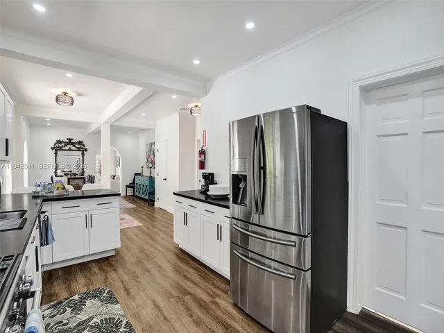a kitchen with granite countertop white cabinets and stainless steel appliances