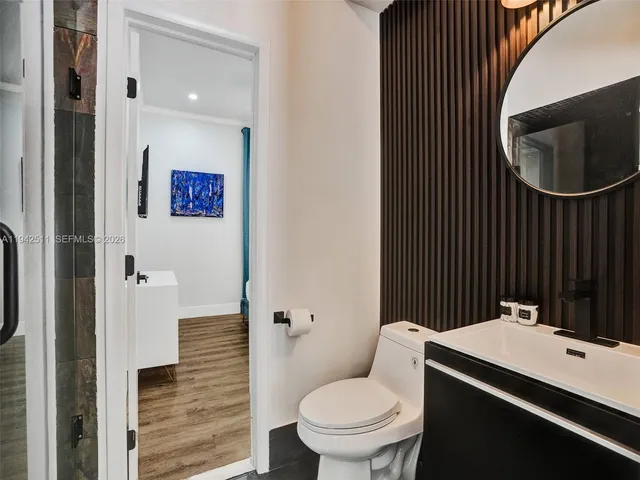 a bathroom with a sink vanity mirror and toilet