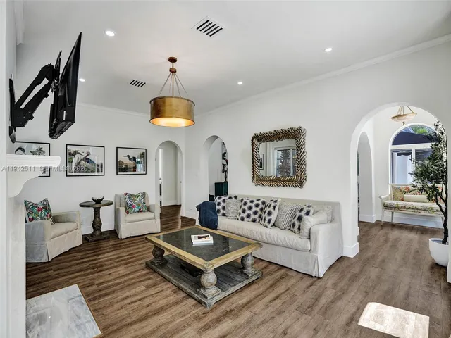 a living room with furniture a fireplace and a chandelier