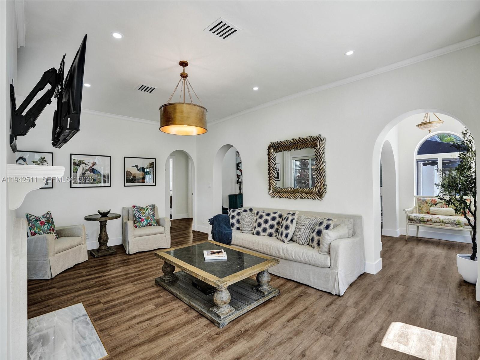 1128 Tyler Street Hollywood, FL 33019 - Photo 3 of 60 a living room with furniture a chandelier and a rug