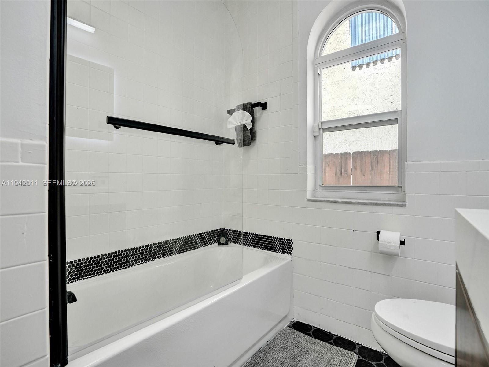 1128 Tyler Street Hollywood, FL 33019 - Photo 33 of 60 a bathroom with a bathtub a window and a shower