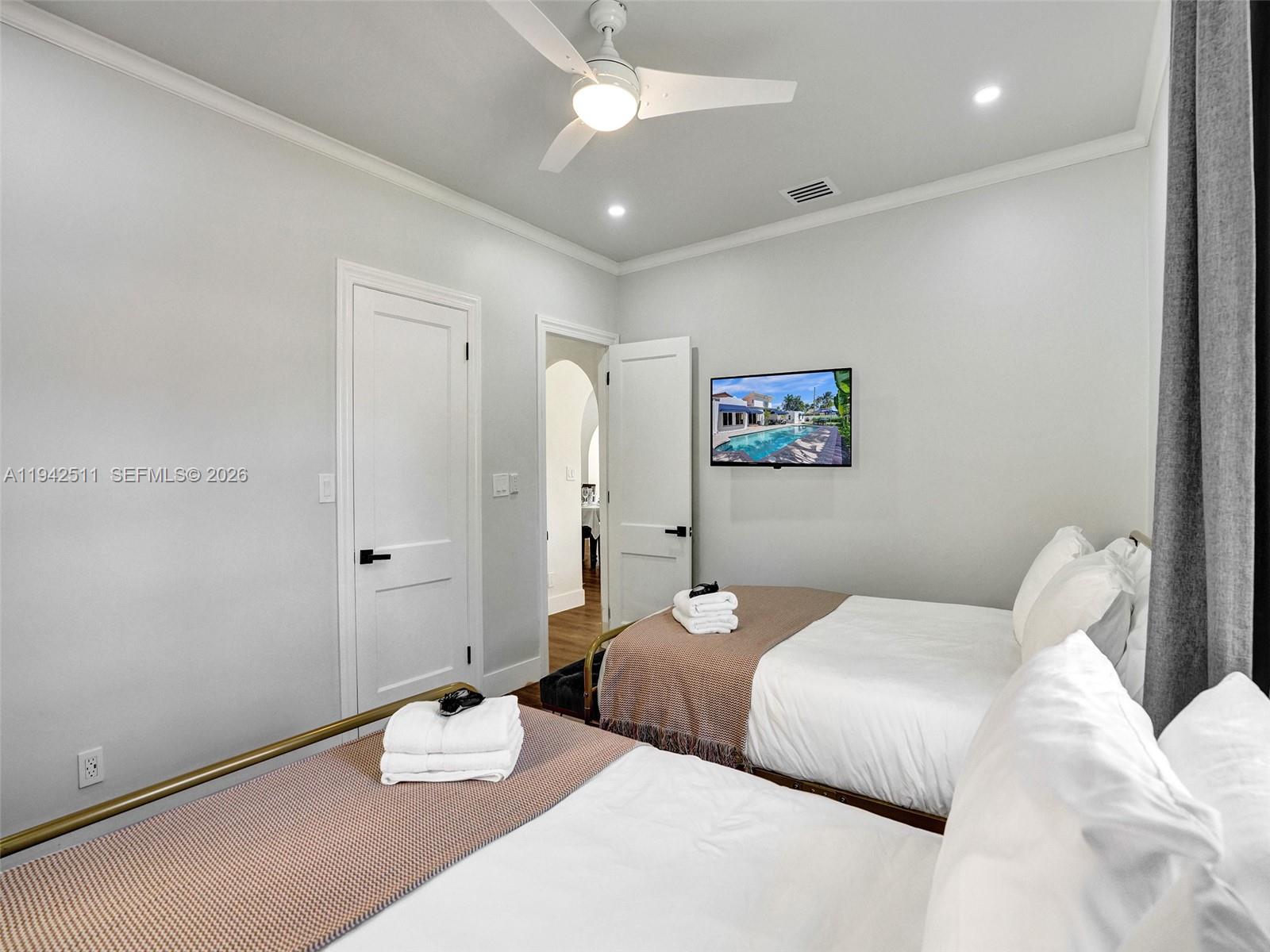 1128 Tyler Street Hollywood, FL 33019 - Photo 34 of 60 a bedroom with a bed and a chandelier