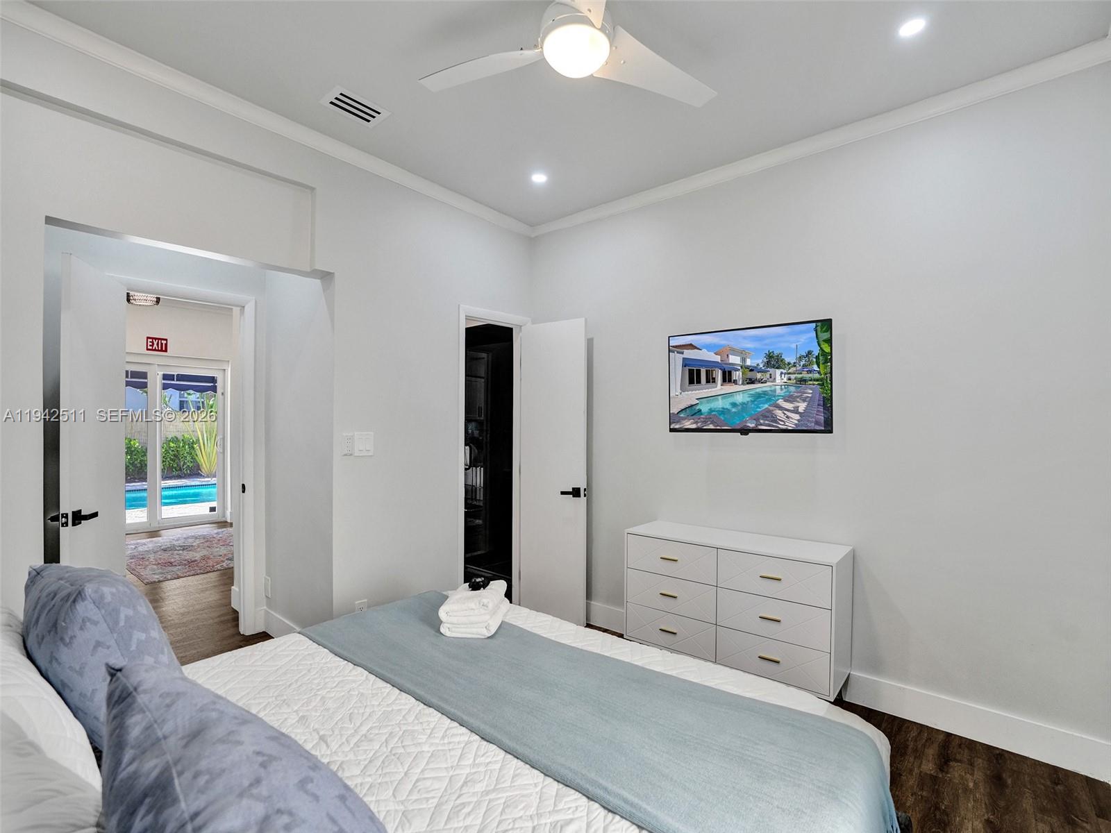 1128 Tyler Street Hollywood, FL 33019 - Photo 35 of 60 a bedroom with a bed and a chandelier