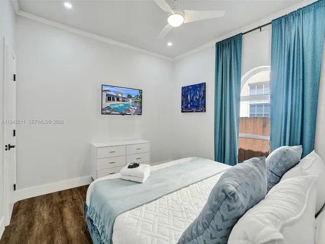 a kitchen with stainless steel appliances granite countertop a refrigerator a stove top oven a sink dishwasher and white cabinets with wooden floor