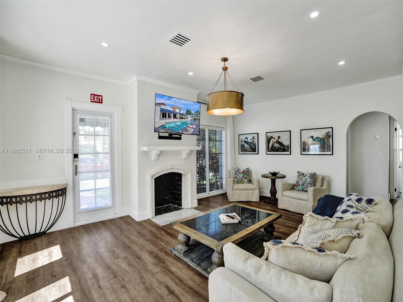 1128 Tyler Street Hollywood, FL 33019 - Photo 4 of 60 a living room with furniture a fireplace and a chandelier