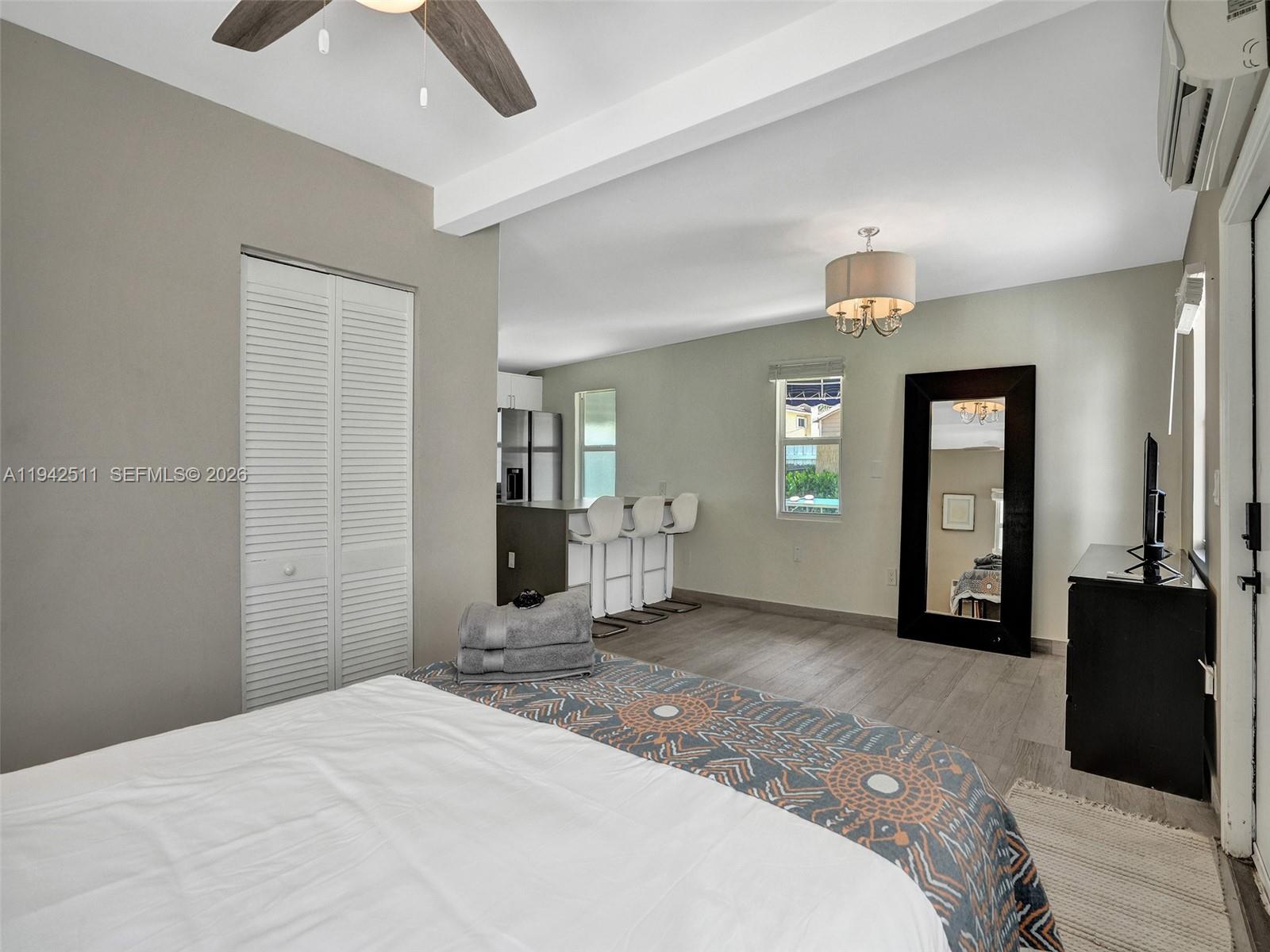 1128 Tyler Street Hollywood, FL 33019 - Photo 41 of 60 a bedroom with a bed and a chandelier