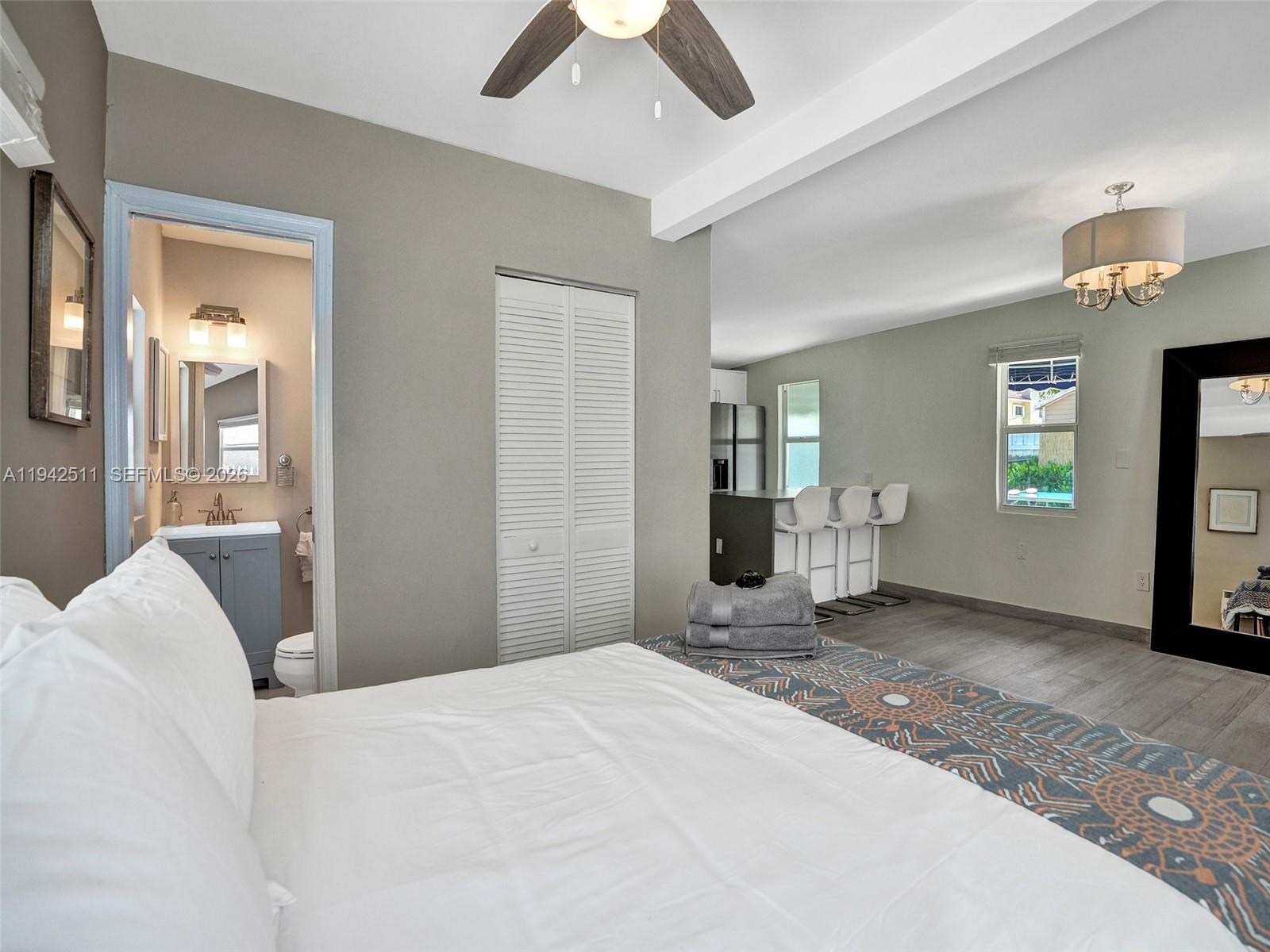 1128 Tyler Street Hollywood, FL 33019 - Photo 42 of 60 a bedroom with a bed and a chandelier