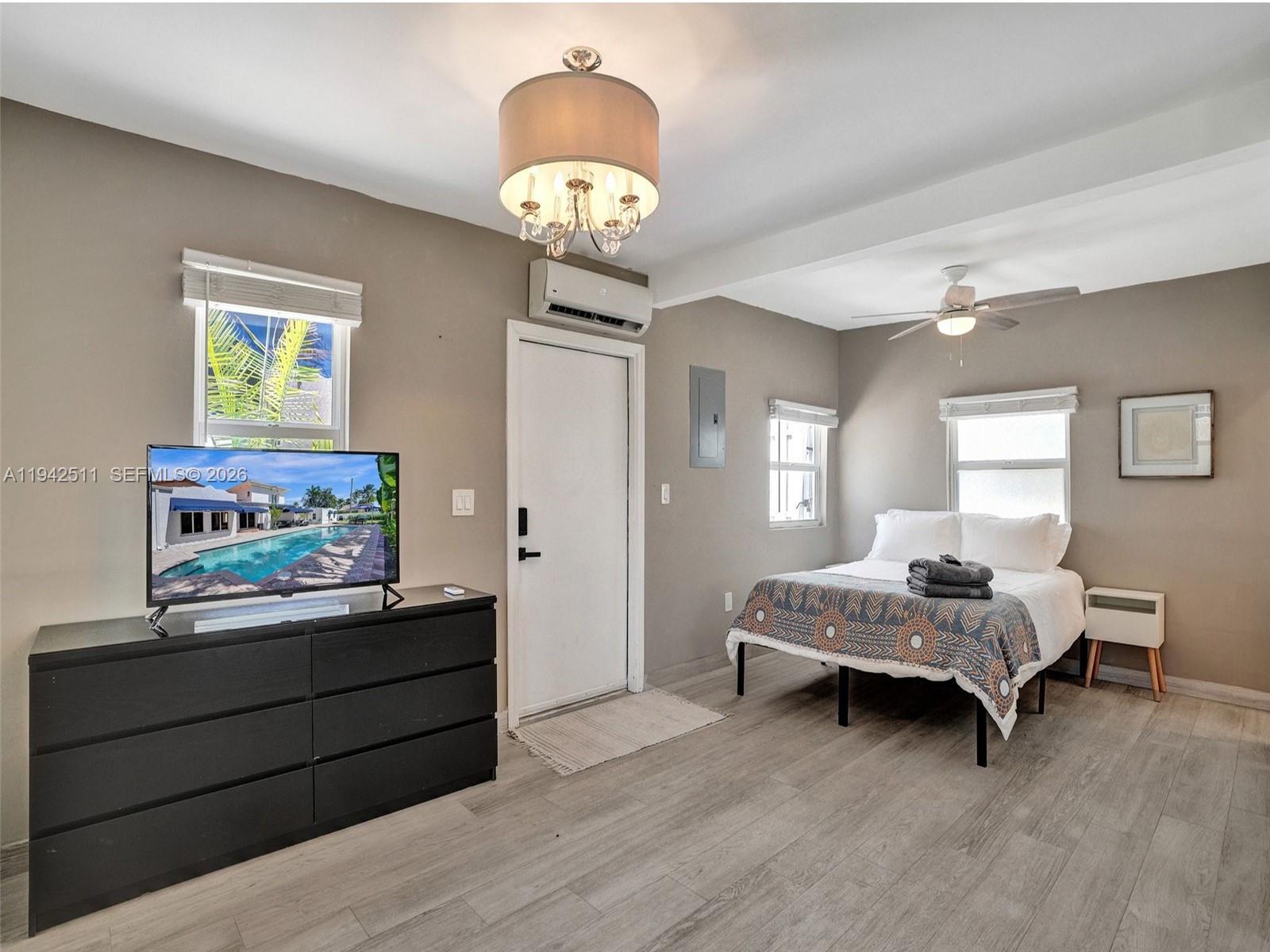 1128 Tyler Street Hollywood, FL 33019 - Photo 43 of 60 a bedroom with a bed and a chandelier