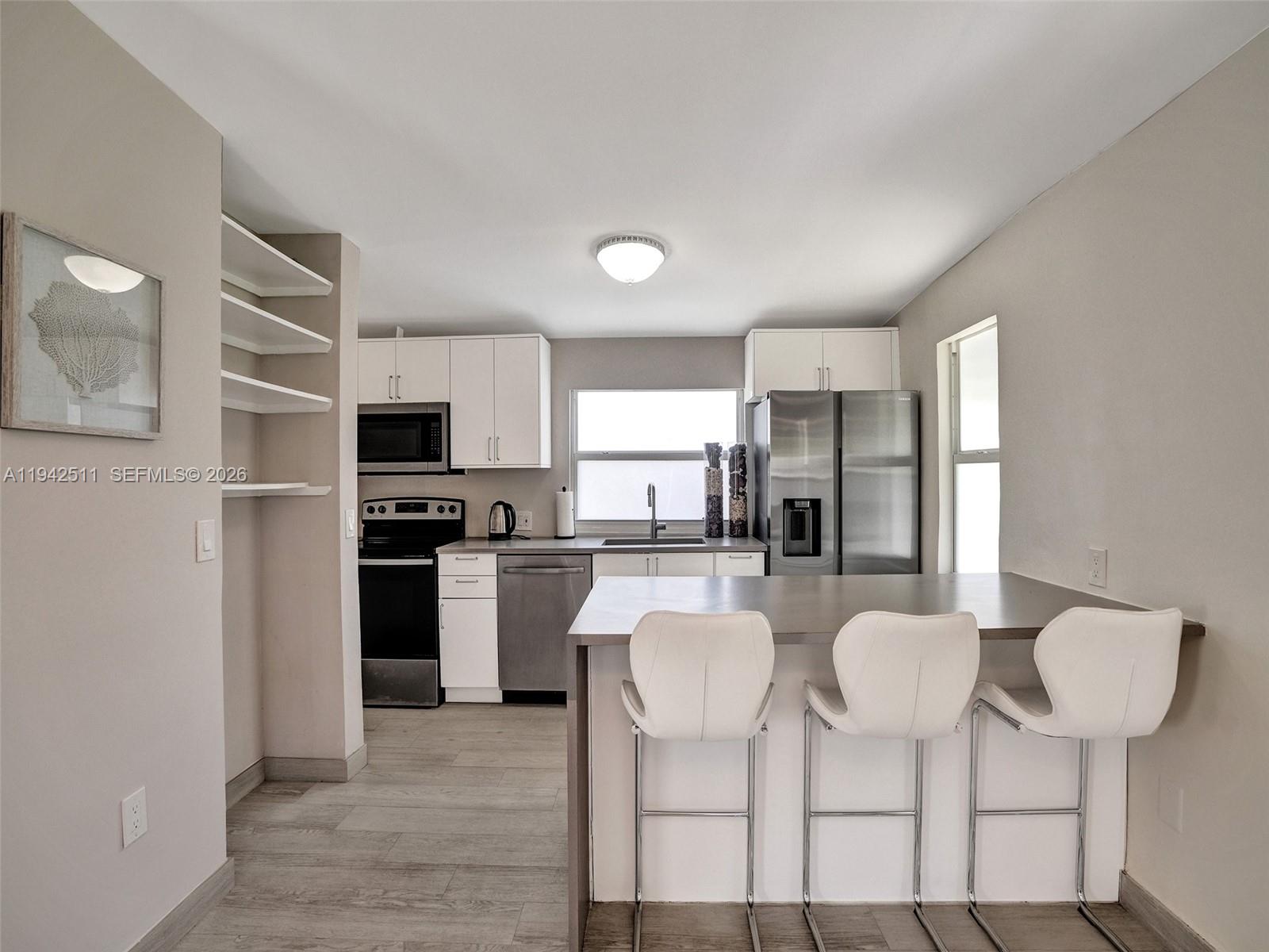 1128 Tyler Street Hollywood, FL 33019 - Photo 45 of 60 a kitchen with stainless steel appliances kitchen island granite countertop a refrigerator and a stove top oven