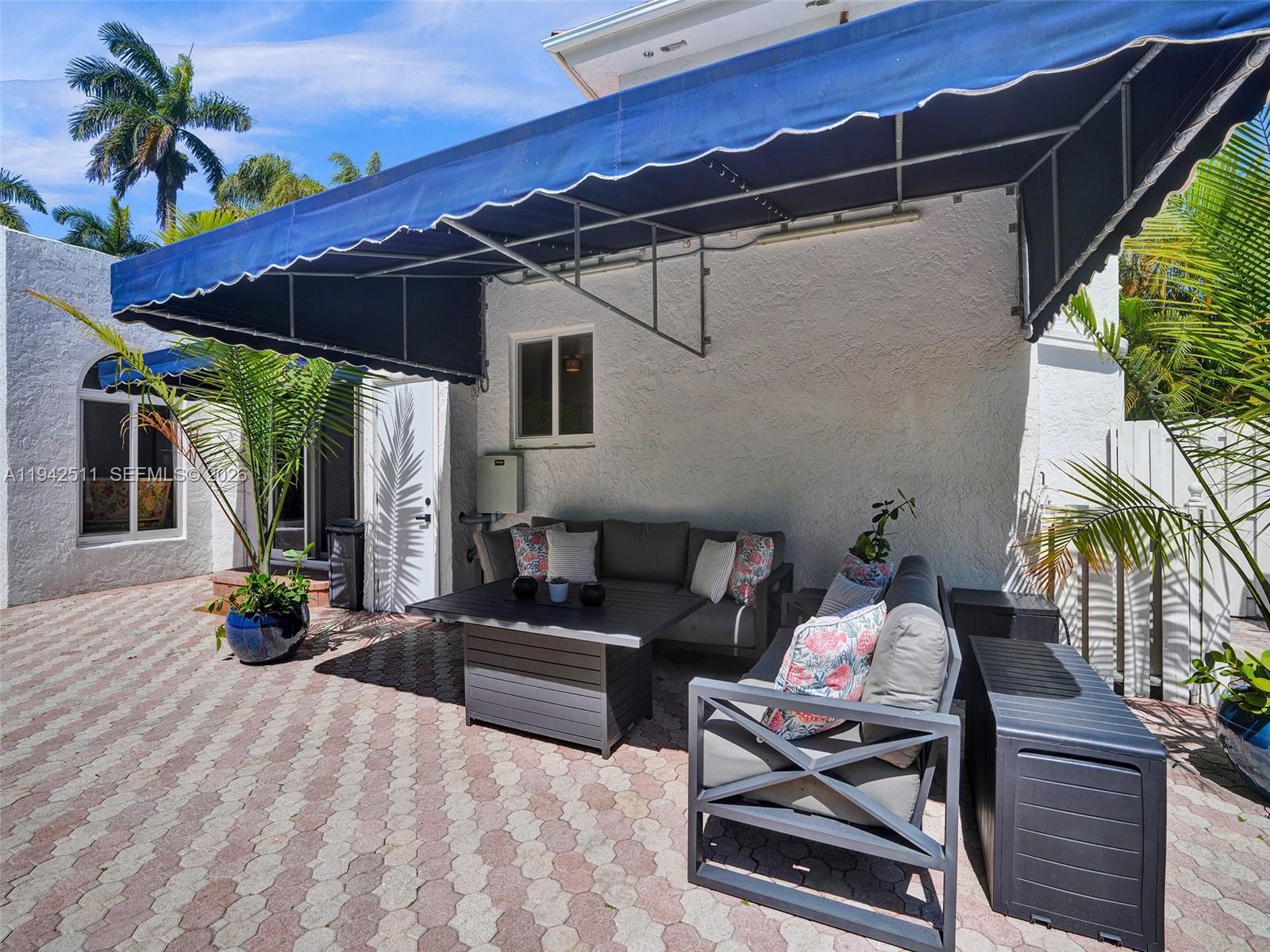 1128 Tyler Street Hollywood, FL 33019 - Photo 51 of 60 a backyard of a house with table and chairs