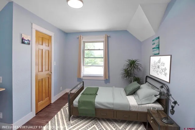 a bedroom with a bed window and table